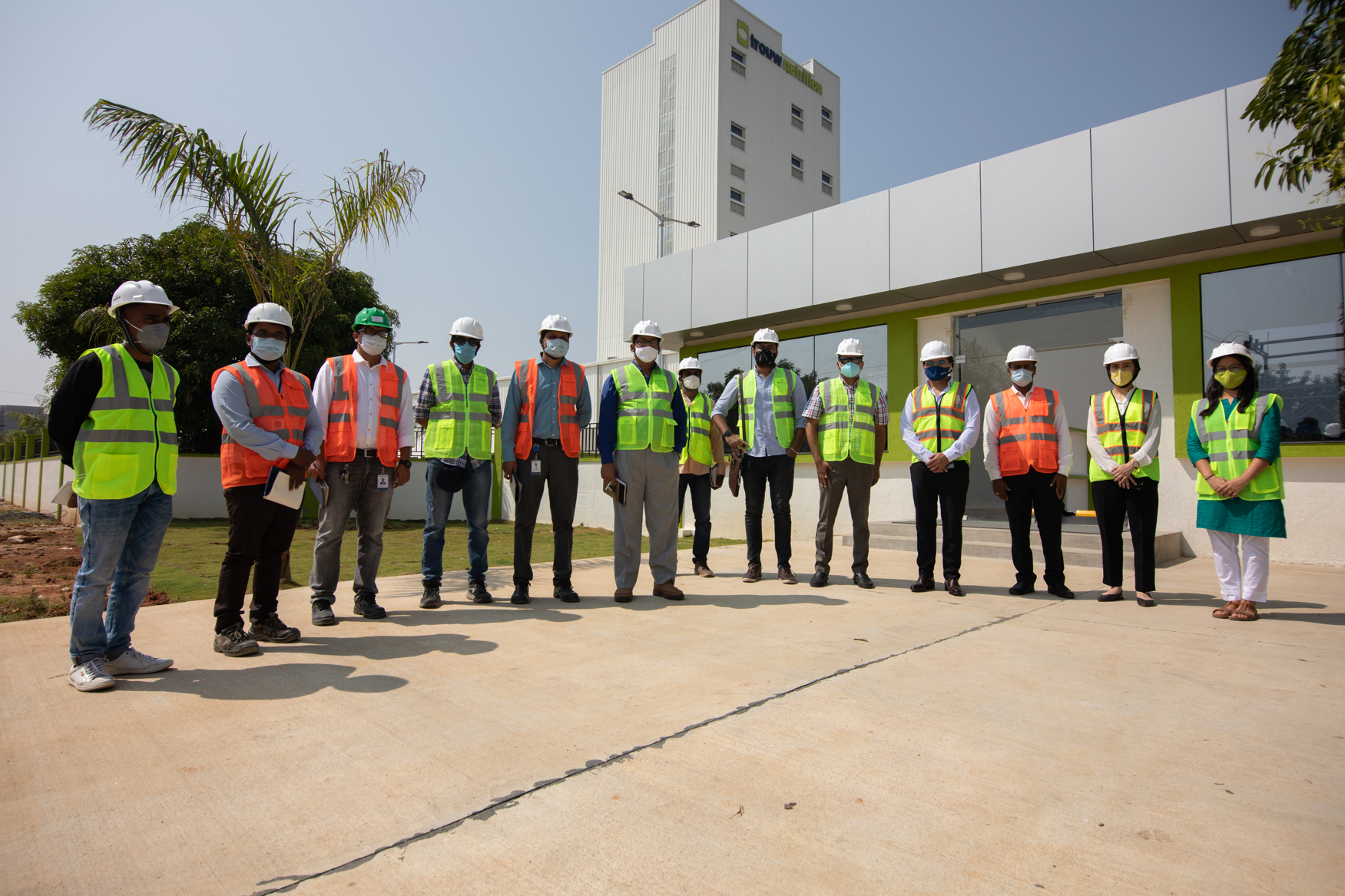 employees at production plant standing infront of the factory